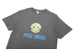 A grey cotton t-shirt featuring a smiley face graphic and the text "I'M FINE," with a logo on one sleeve.