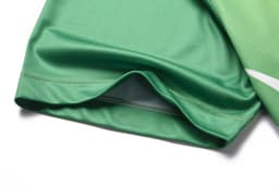 A green multi-sport t-shirt featuring a smooth fabric and a stitched hem. It has a logo present.
