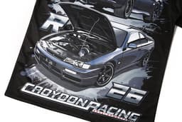 A black polyester t-shirt featuring a detailed graphic of a grey sports car with an open bonnet and a logo present.