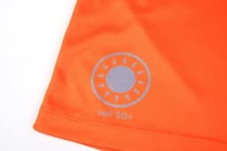 An orange quarter-zip suit featuring a sun logo, designed as a uniform for lifeguards.