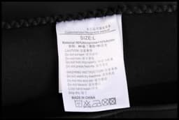 A label featuring washing instructions and care details for a black anti-chlorine swimming coat made of neoprene and nylon.