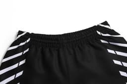 Black football shorts with a striped design and an elastic waistband, featuring a branding logo.