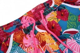 A vibrant women's beach shirt and shorts set featuring a floral pattern with pink, blue, and yellow colours. It has a logo.
