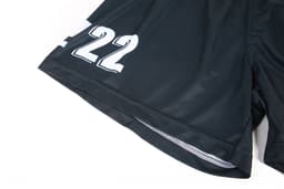 Black volleyball uniform shorts featuring a number design and a logo. The fabric appears lightweight and durable.