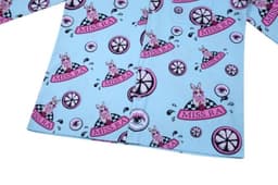 A light blue shirt featuring a playful pattern with pink bunnies, wheels, and various circular designs.