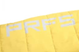 A close-up of a bright yellow fabric with quilted texture and a logo in grey.