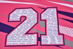 A bright pink hoodie with a large number "21" prominently displayed, featuring various names around the number.