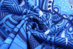 A blue Aboriginal cotton T-shirt featuring intricate patterns and swirls of various shades of blue.
