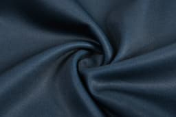 A close-up of dark blue fabric, showcasing a smooth texture with a swirling pattern.