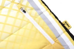 A close-up of a quilted coat with yellow and black sections, featuring a zip and a branding label.