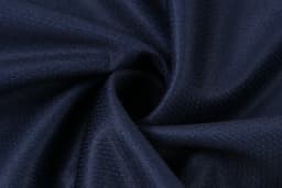 A close-up of navy fabric, showcasing a smooth texture with subtle patterns. The material is gathered in a spiral shape.