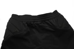 Black soccer goalkeeper pants featuring a drawstring waist and green stitching details. Includes a logo on the waistband.