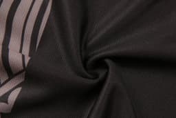 Aboriginal/Indigenous shorts in a black fabric with a patterned design, featuring a logo.