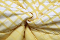 A yellow and white checkered fabric featuring a puffer design, suitable for winter coats with removable sleeves and hood.