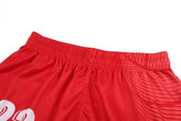 Red women's volleyball uniform shorts featuring an elastic waistband and a logo on the side.