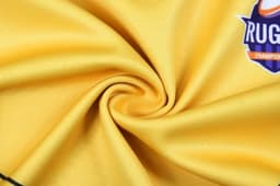 A smooth, yellow fabric with a logo in the corner, showing a spiral pattern.