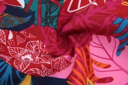 A vibrant mix of floral patterns in shades of pink, red, blue, and green, featuring a smooth fabric texture.