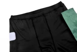 Black TAG SHORTS featuring a green accent and a logo on the fabric.
