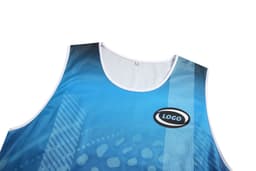 A blue Aboriginal singlet vest with a logo and a patterned design on the fabric.