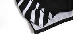 A black and white reversable varsity jacket with contrasting stripes at the hem. Features a logo on one side.