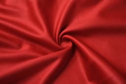 A textured fabric in vibrant red, showcasing a smooth, woven pattern with a slight sheen.
