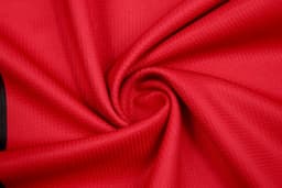 A red fabric with a textured pattern, arranged in a spiral. The material appears lightweight and smooth.