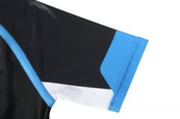 A close-up of a sports uniform sleeve featuring black fabric with blue and white detailing and a logo.