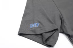 A grey cotton T-shirt featuring a small logo on the sleeve, labelled "DTF".