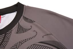 A grey jersey with intricate black patterns and a black neckline, featuring a logo on the fabric.