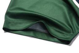 A green polo shirt in a lightweight fabric with a hem detail. It features a logo or branding.