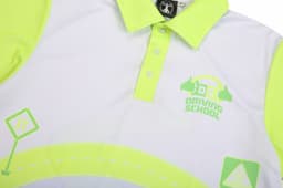 A bright yellow and white driving school polo shirt featuring a logo and graphic elements related to driving.