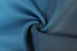 A close-up of blue fabric showing a smooth, textured surface, ideal for rugby uniform shorts.