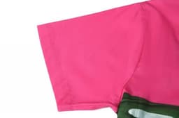 A pink beach shirt with a green section at the bottom, featuring a logo. Part of a women's sports uniform.