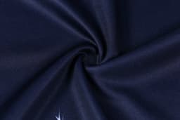 A close-up of dark navy fabric displaying a smooth texture, featuring a logo in the corner.