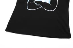 A black cotton t-shirt featuring a printed design with a logo on it, showcasing a close-up view of the fabric.