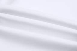 A close-up of smooth, white fabric, showcasing the texture and quality of the material used in cricket uniform pants.