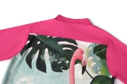 A pink women's beach shirt featuring a large tropical print with a flamingo and green leaves.