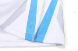 A sports uniform featuring a white base with blue and grey angular designs and a branded logo.