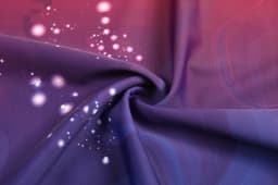 A close-up of fabric featuring a gradient of purple hues with subtle dots and patterns in lighter shades.