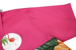 A pink beach shirt featuring tropical prints and a logo, showcasing vibrant colours and a relaxed style.