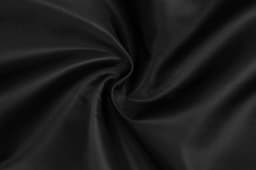 A close-up view of black fabric, displaying a smooth and flowing texture, with folds creating a swirl pattern.