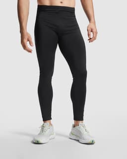 Black men's leggings with a fitted design, complemented by a white branded logo, and styled with light athletic shoes.