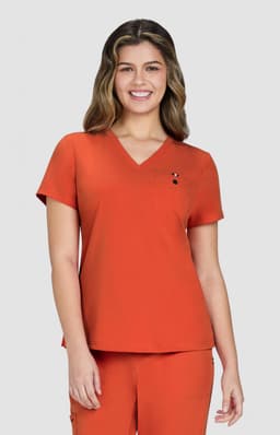 An orange V-neck top worn by a smiling woman, featuring a small logo on the chest.