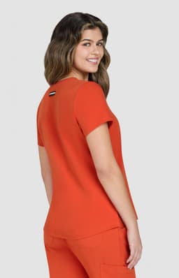 An orange top with a relaxed fit, featuring short sleeves and a logo on the back.
