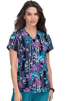 A floral print scrub top in navy, featuring pink, purple, and white flowers, with a V-neck and short sleeves.
