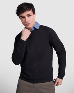 A black sweatshirt worn by a young man, featuring a layered look with a blue collared shirt underneath.