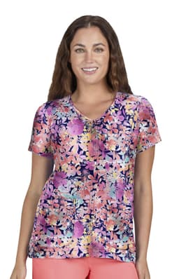 A floral print top featuring vibrant colours such as pink, purple, and white, displayed on a smiling woman.