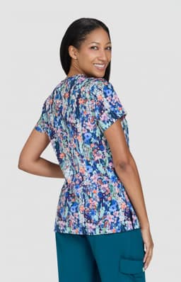 A floral print top with a variety of colours, featuring short sleeves and a relaxed fit. It has a logo.