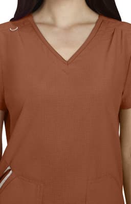 A Sari Top in rust colour features a V-neck design and short sleeves, with a pocket and small embellishment.