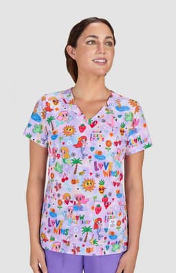 A pink scrub top featuring a vibrant print with various playful designs and a logo.